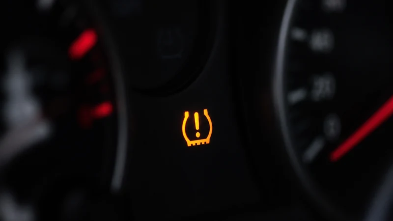 TPMS warning light on a dashboard next to a gauge showing 26 PSI — the light only comes on 25% below the recommended 35 PSI