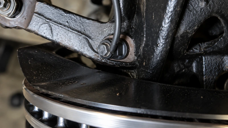 Close-up of a Honda Civic wheel-speed sensor secured to the steering knuckle beside the brake disc
